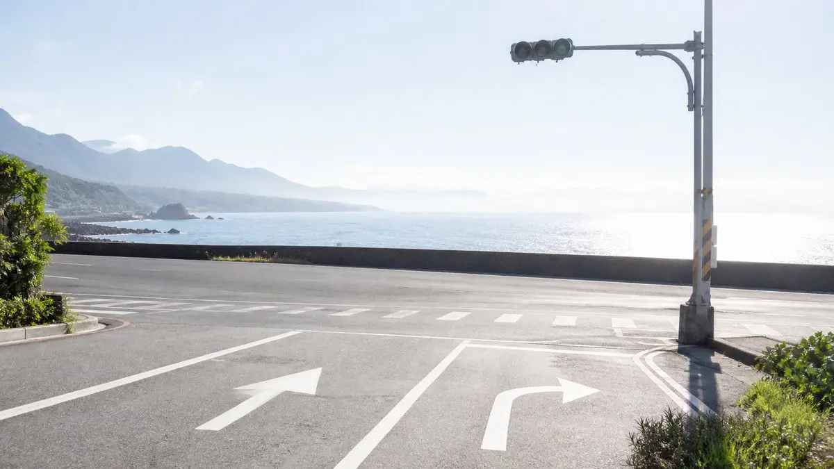 濱海公路上的十字路口，地面有直行與轉彎的箭頭